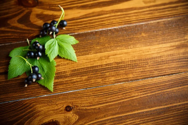 ahşap bir masa üzerinde olgunlaşmış meyveler siyah kuş üzümü