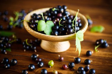 ahşap bir masa üzerinde olgunlaşmış meyveler siyah kuş üzümü