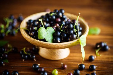 ahşap bir masa üzerinde olgunlaşmış meyveler siyah kuş üzümü