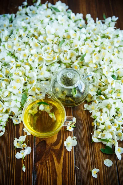 Tee Mit Jasminblüten Einer Glasteekanne Auf Einem Tisch — Stockfoto