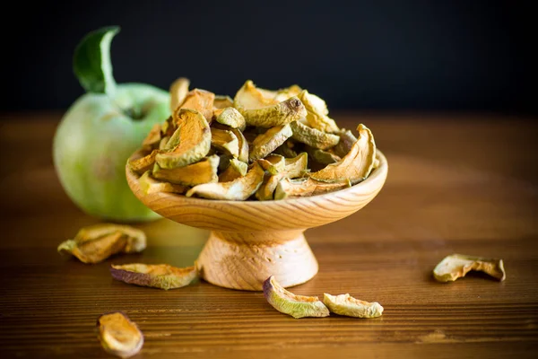 Dried apples in a bowl with a fresh apple — Stock Photo, Image