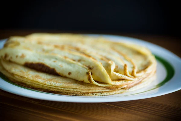 Panqueques finos apilados en un plato en una pila —  Fotos de Stock