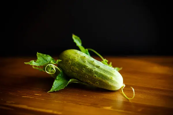 Verse groene komkommers op een houten tafel — Stockfoto