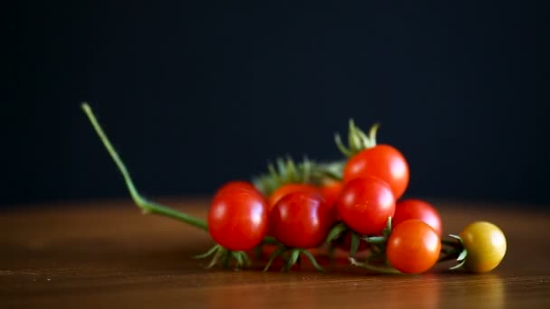 Pequeños tomates rojos cereza maduros en un tazón de madera — Vídeos de Stock