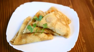 bir tabak içinde haşlanmış lahana dolması ince kızarmış krep