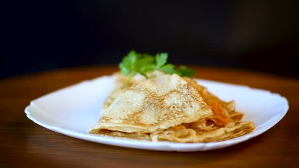 Tortitas fritas finas rellenas con repollo guisado en un plato — Vídeos de Stock