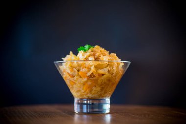 ahşap bir masa üzerinde bir cam kapta havuç ile haşlanmış lahana