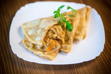 ince kızarmış krep ahşap bir masa bir tabağa haşlanmış lahana dolması