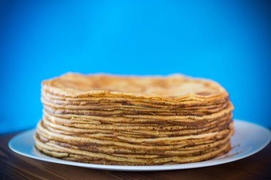 mavi bir arka plan üzerine bir tabak içinde ince krep büyük yüksek yığını