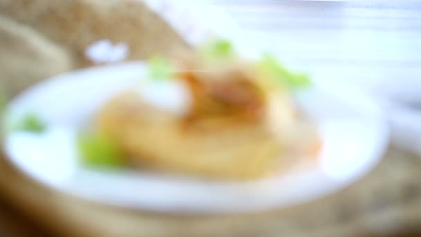 Тонкие блинчики с листьями салата и беконом в тарелке — стоковое видео