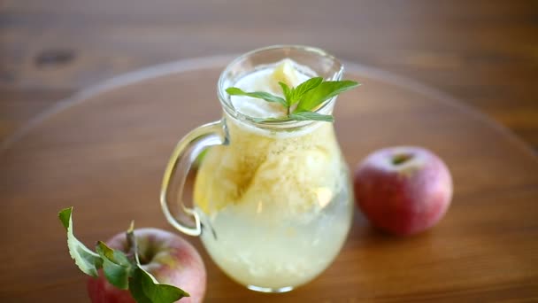 Летний сладкий холодный компот из свежих яблок с веточкой мяты — стоковое видео