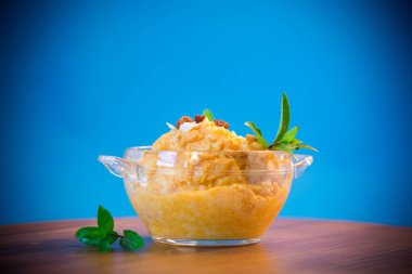 Kuru üzüm ve fındık mavi bir arka plan üzerinde bir cam kasede ile haşlanmış tatlı kabak püresi