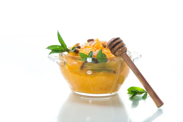 煮甜南瓜粥用葡萄干和坚果在一个玻璃碗在白色背景上 — 图库照片
