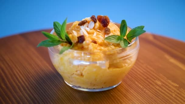 煮甜南瓜粥用葡萄干和坚果在玻璃碗里 — 图库视频影像