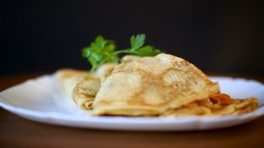 bir tabak içinde haşlanmış lahana dolması ince kızarmış krep