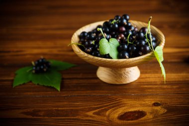 ahşap bir masa üzerinde olgunlaşmış ham meyveleri siyah kuş üzümü