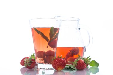 Olgun kırmızı çilek beyaz zemin üzerinde bir cam sürahi içinde tatlı komposto