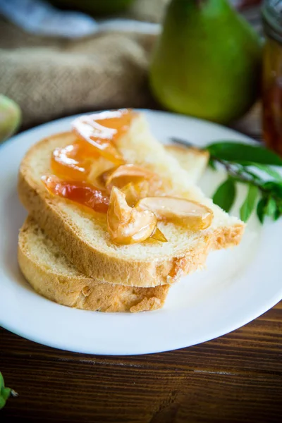 Trozos de pan con mermelada de frutas caseras dulces de peras y manzanas en un plato — Foto de Stock