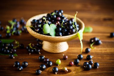 ahşap bir masa üzerinde olgunlaşmış ham meyveleri siyah kuş üzümü