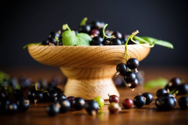 ahşap bir masa üzerinde olgunlaşmış ham meyveleri siyah kuş üzümü
