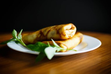 siyah bir zemin üzerine bir tabak kızarmış ince krep dolması