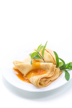 beyaz bir arka plan üzerine bir tabak içinde reçelli tatlı ince krep