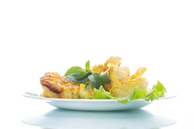 meyilli bir plaka üzerinde beyaz bir arka plan üzerinde kızarmış karnabahar