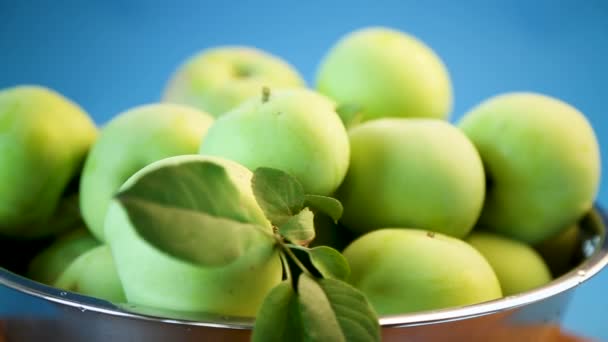 Šťavnatá jablka zelené v misce na modré — Stock video
