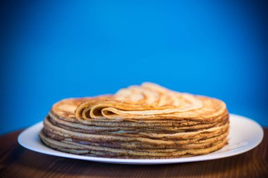 mavi bir arka plan üzerine bir tabak içinde ince krep büyük yüksek yığını