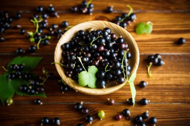 ahşap bir masa üzerinde olgunlaşmış meyveler siyah kuş üzümü