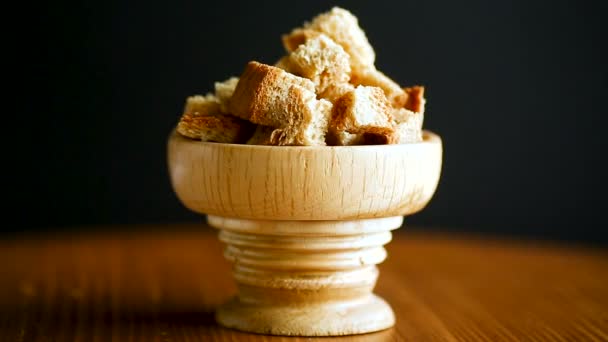 Migas de pan frito cortadas en cubitos en un tazón de madera — Vídeo de stock