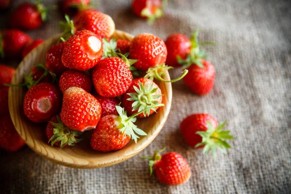 Reife rote Erdbeere auf einem Tisch mit Klette — Stockfoto