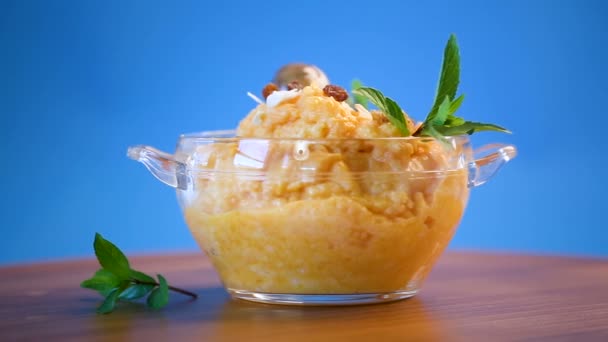 Boiled sweet pumpkin porridge with raisins and nuts in a glass bowl — Stock Video