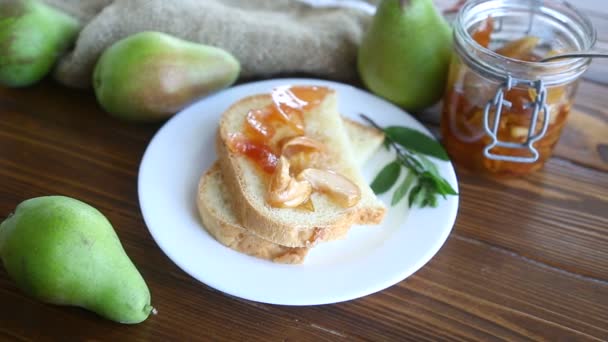 Trozos de pan con mermelada de frutas caseras dulces de peras y manzanas en un plato — Vídeo de stock