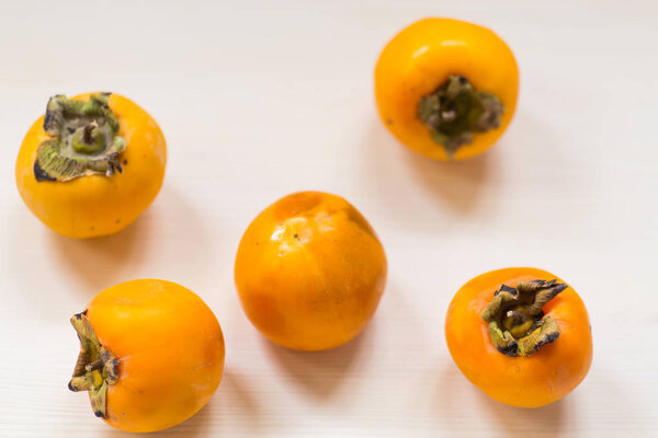 ripe exotic orange persimmon on wooden background
