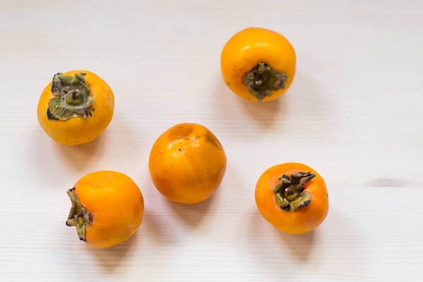 ripe exotic orange persimmon on wooden background