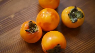 ahşap arka plan üzerinde olgunlaşmış egzotik turuncu Trabzon hurması