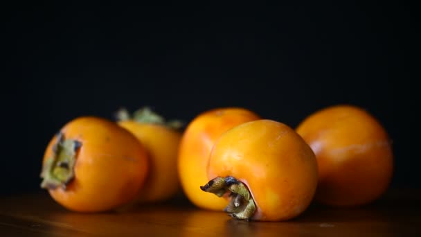 Ripe exotic orange sweet persimmon on black — Stock Video