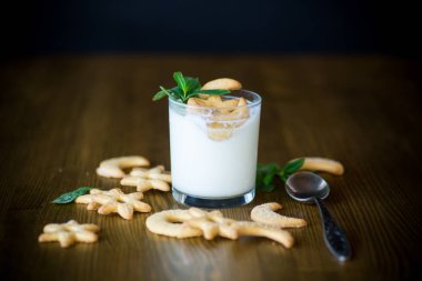 kurabiye ahşap bir masa üzerinde bir cam bardak ile tatlı ev yapımı yoğurt