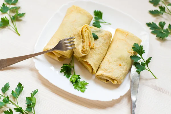 bir tabak içinde haşlanmış lahana dolması ince kızarmış krep