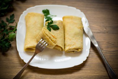 bir tabak içinde haşlanmış lahana dolması ince kızarmış krep