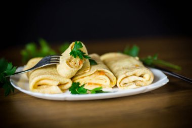 bir tabak içinde haşlanmış lahana dolması ince kızarmış krep