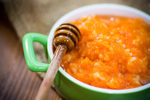 Boiled sweet pumpkin porridge with honey in a plate on the table