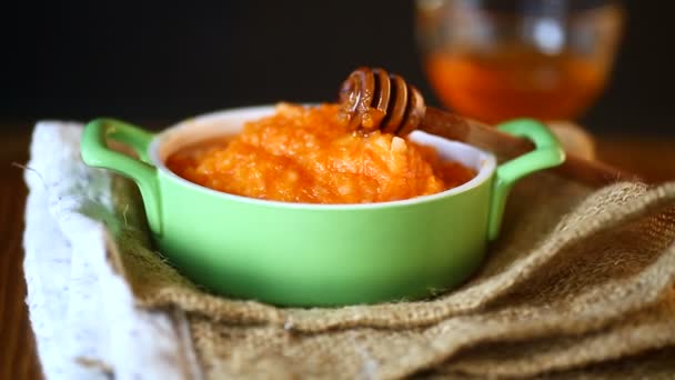 Boiled sweet pumpkin porridge with honey in a plate — Stock Video