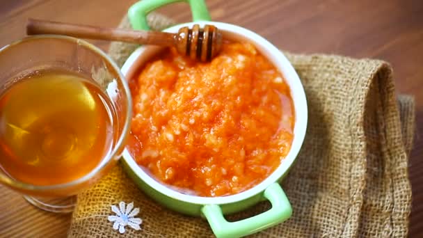 Boiled sweet pumpkin porridge with honey in a plate — Stock Video