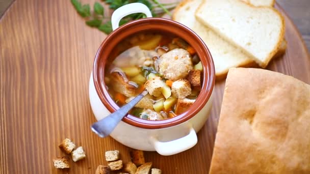 Soupe de légumes aux haricots et boulettes de viande dans un bol en céramique — Video