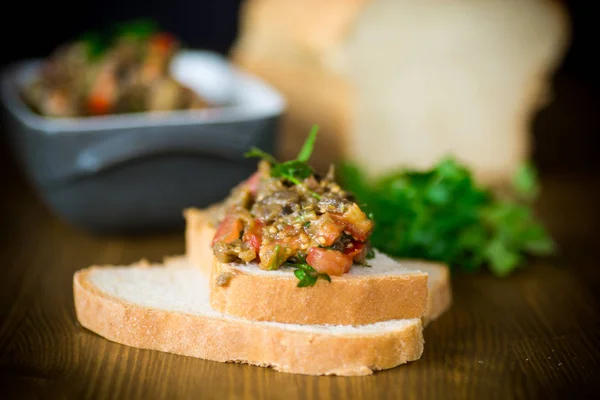 木製テーブルの上のパンのスライス トマトと茄子のキャビア — ストック写真