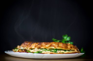 Karnabahar ve yeşillik bir plaka üzerinde ahşap bir masa ile kızartılmış omlet