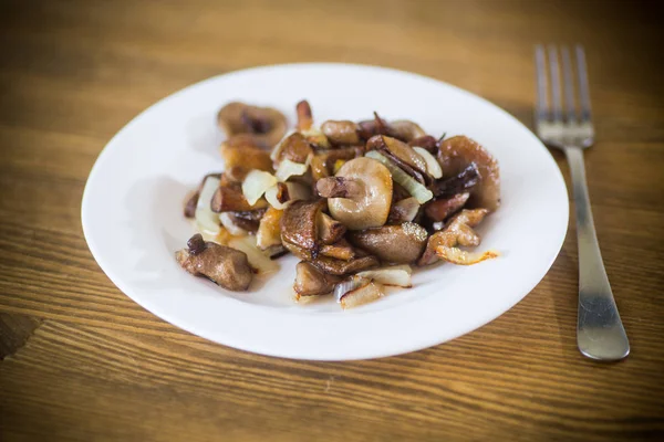Болетові гриби смажені з цибулею в тарілці — стокове фото