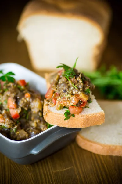 Caviar de berinjela com tomates e uma fatia de pão — Fotografia de Stock